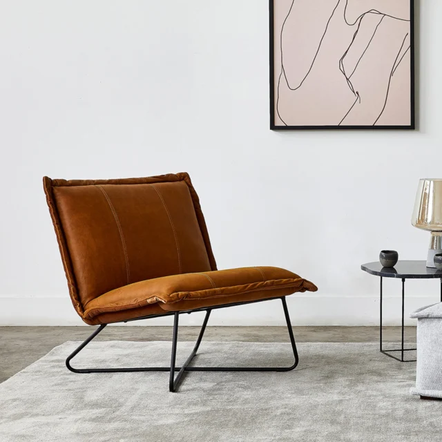 The generously proportioned Xander chair in top-grain aniline leather features cognac velvet fabric on the back of the chair – a surprise element which warms and softens the design.