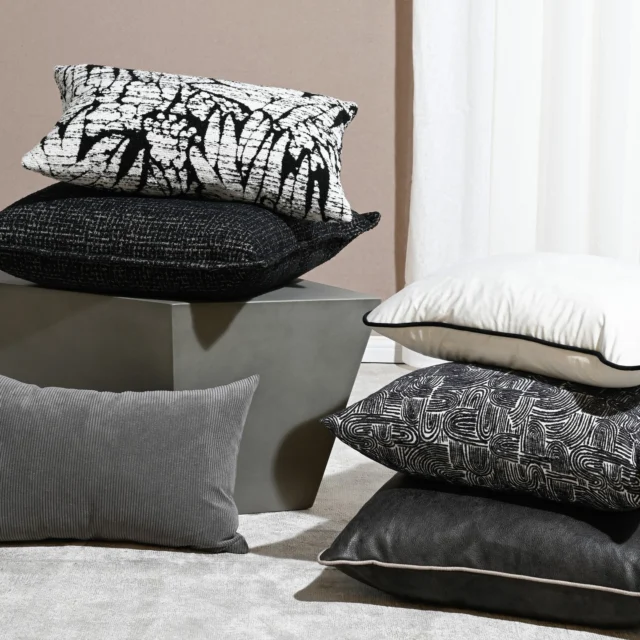 Our Sable cushion collection brings visual interest through dark, light, solid and patterned weaves and textures designed to complement earthy neutrals such as taupe, safari, and warm ivory not usually associated with black. Displayed atop the Bantry cement coffee table, these cushions are designed to anchor a room with tonal depth and texture.